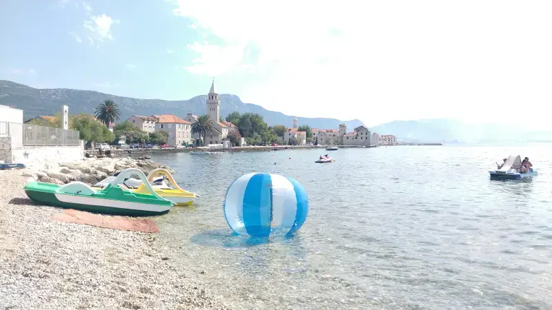 Image of a beach ball floating in the water close to beach in Kastel Stafilic